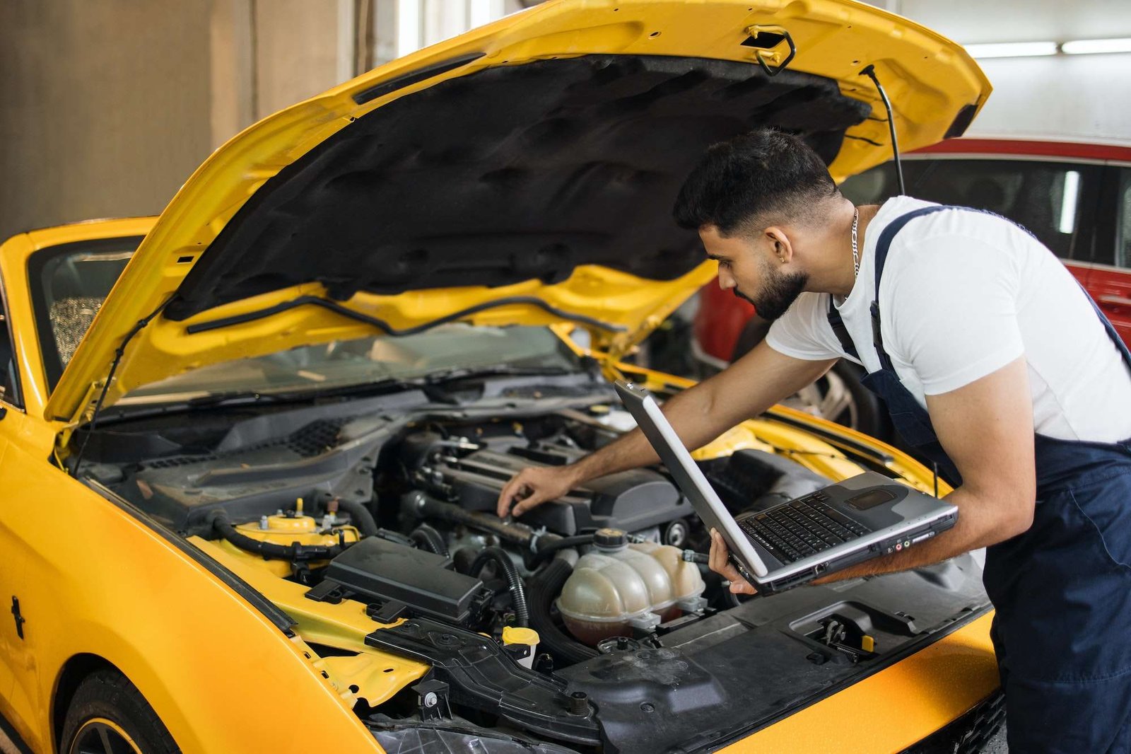 Engineer young man looking at inspection vehicle details under car hood
