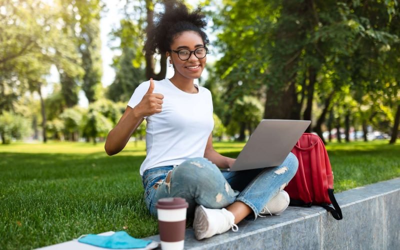 African Student Girl Gesturing Like Posing With Laptop Outdoor
